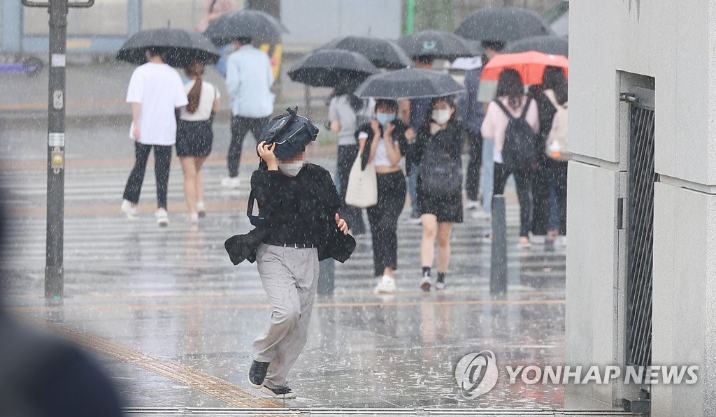 서울 서대문구 연세대학교에서 한 시민이 가방으로 비를 막으며 뛰어가고 있다. [연합뉴스 자료사진]