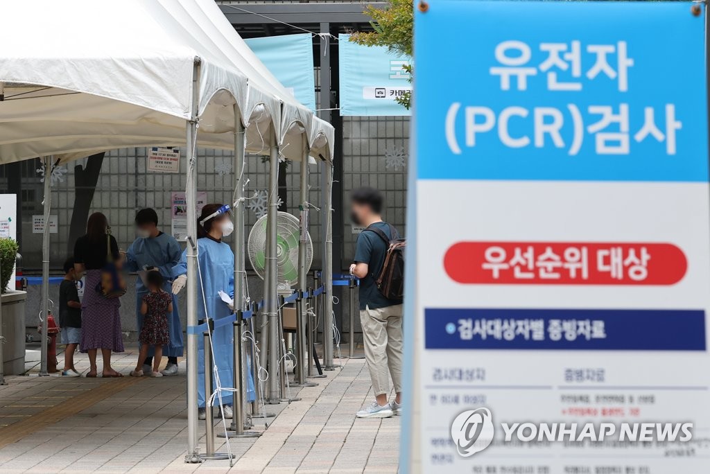 A health worker guides a visitor at a COVID-19 testing station in Seoul's southern district of Seocho on June 17, 2022. (Yonhap)
