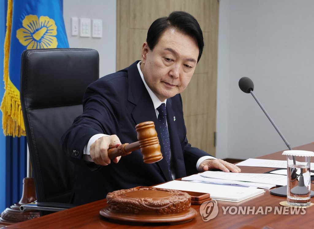 El presidente surcoreano, Yoon Suk-yeol, golpea el mazo para declarar el inicio de una reunión del Gabinete, el 21 de junio de 2022, en la oficina presidencial, en Seúl.