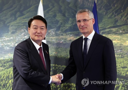 South Korean President Yoon Suk-yeol (L) shakes hands with North Atlantic Treaty Organization Secretary General Jens Stoltenberg prior to their talks at the IFEMA Convention Center in Madrid, in this June 30, 2022, file photo. Yoon discussed South Korea's plans to enter into a new partnership agreement with the organization and open a mission to NATO in Belgium. (Yonhap)