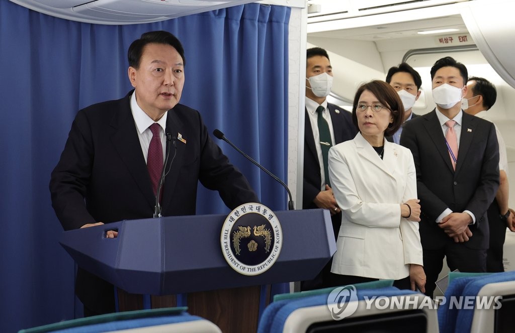 El presidente surcoreano, Yoon Suk-yeol (en el podio), habla durante una conferencia llevada a cabo, el 30 de junio de 2022 (hora local), en el avión presidencial, con rumbo a Corea del Sur, tras una visita de cuatro días a Madrid, España, para asistir a la cumbre de la Organización del Tratado del Atlántico Norte (OTAN).