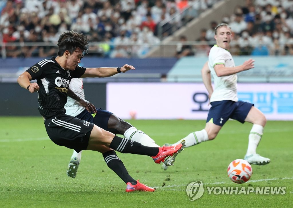 Yang Hyun-jun of Team K League (L) takes a shot against Tottenham Hotspur during the teams' exhibition match at Seoul World Cup Stadium in Seoul on July 13, 2022. (Yonhap)