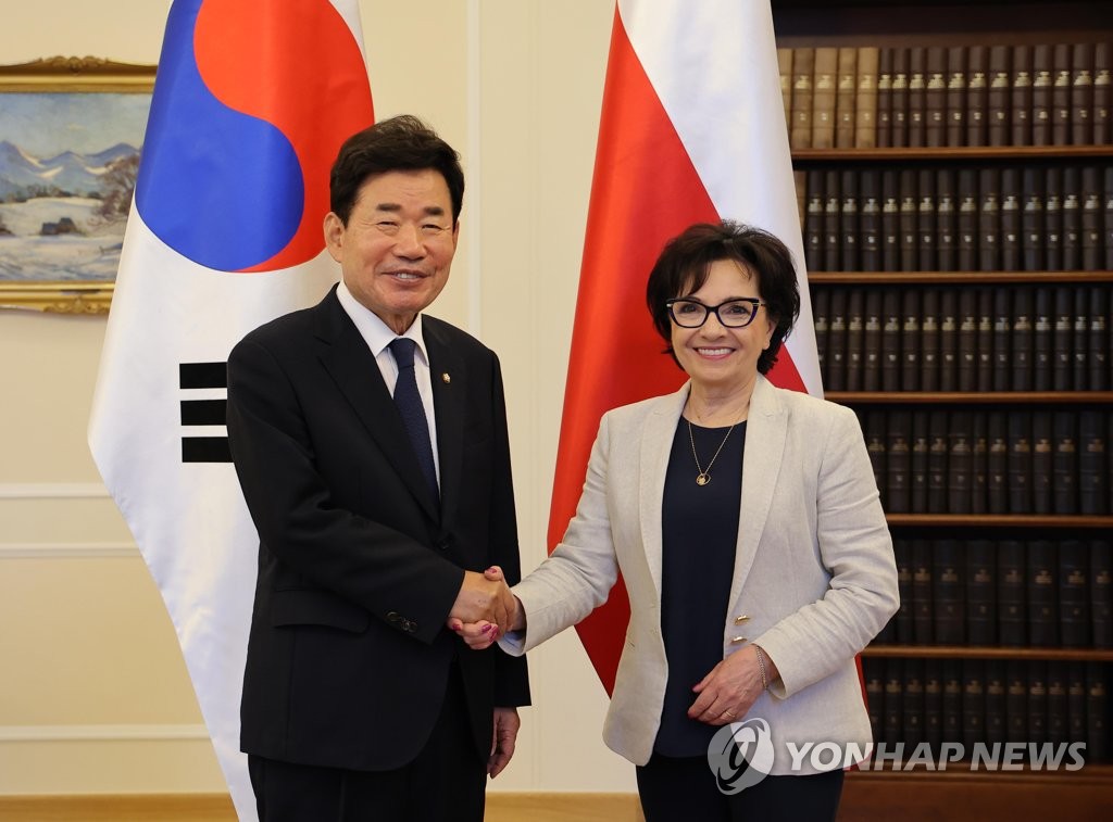 National Assembly Speaker Kim Jin-pyo (L) shakes hands with Elzbieta Witek, the speaker of the Sejm, the lower house of the Polish parliament during their meeting in Warsaw on Aug. 5, 2022, in this photo released by Kim's office. (PHOTO NOT FOR SALE) (Yonhap)