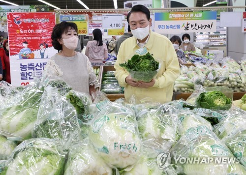 President Yoon Suk-yeol (R) checks vegetable prices at a discount supermarket in southern Seoul on Aug. 11, 2022. (Yonhap)