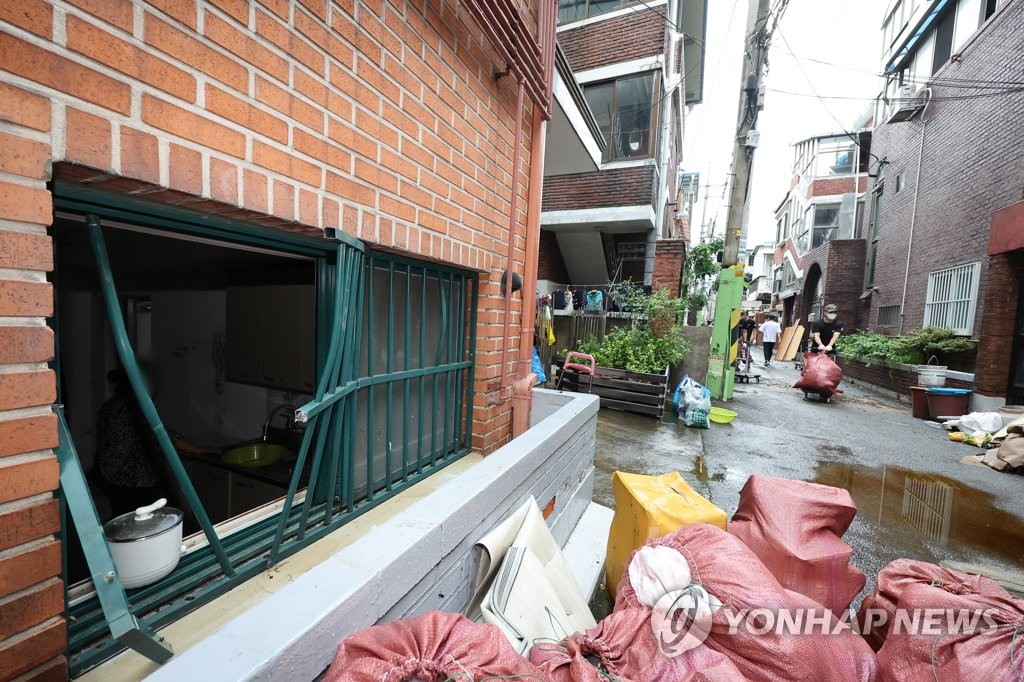 京畿道軍浦市の住宅地にある建物。半地下の部屋の窓を壊して浸水から逃れたとみられる＝１１日、軍浦（聯合ニュース）