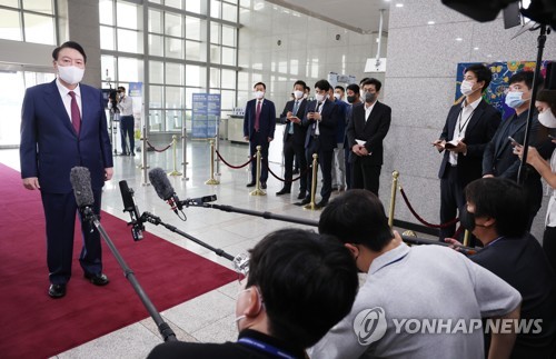 El presidente surcoreano, Yoon Suk-yeol (primero por la izda.), habla con los periodistas, el 16 de agosto de 2022, tras su llegada a la oficina presidencial, en Seúl.
