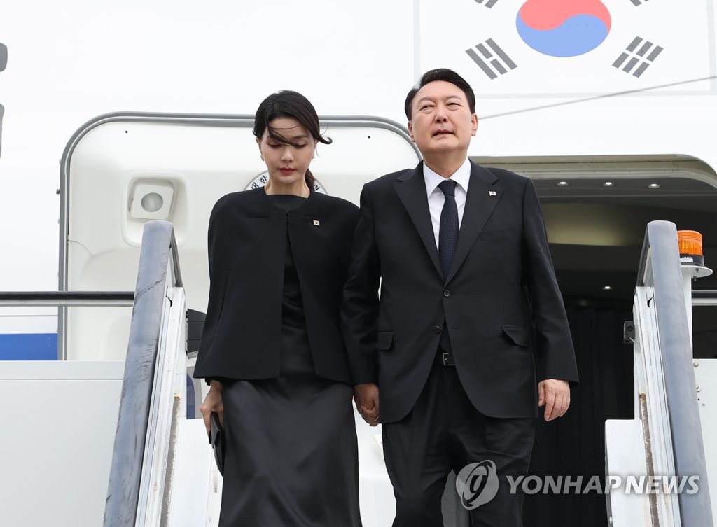 El presidente surcoreano, Yoon Suk-yeol (dcha.), y la primera dama, Kim Keon-hee, llegan al Aeropuerto de Londres Stansted, en la capital británica, el 18 de septiembre de 2022 (hora local), para asistir al funeral estatal de la reina Isabel II.