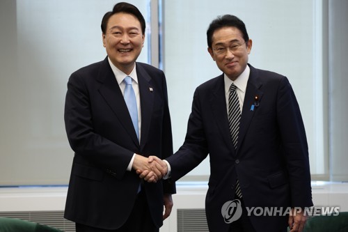 South Korean President Yoon Suk-yeol (L) and Japanese Prime Minister Fumio Kishida shake hands ahead of their summit in New York on Sept. 21, 2022. (Yonhap)