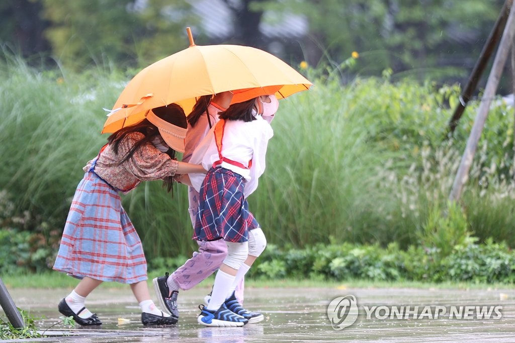 서울시청 인근에서 어린이들이 함께 우산을 쓴 채 이동하고 있다. [연합뉴스 자료사진]