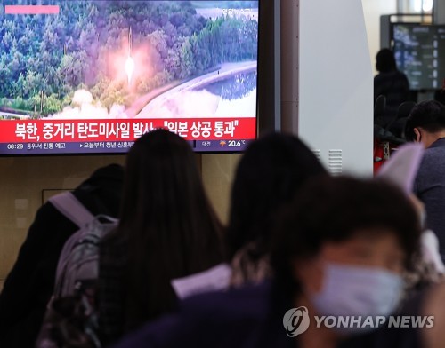 This photo, taken Oct. 4, 2022, shows citizens watching TV news at Seoul Station in central Seoul that reported North Korea fired an intermediate-range ballistic missile over Japan. (Yonhap)