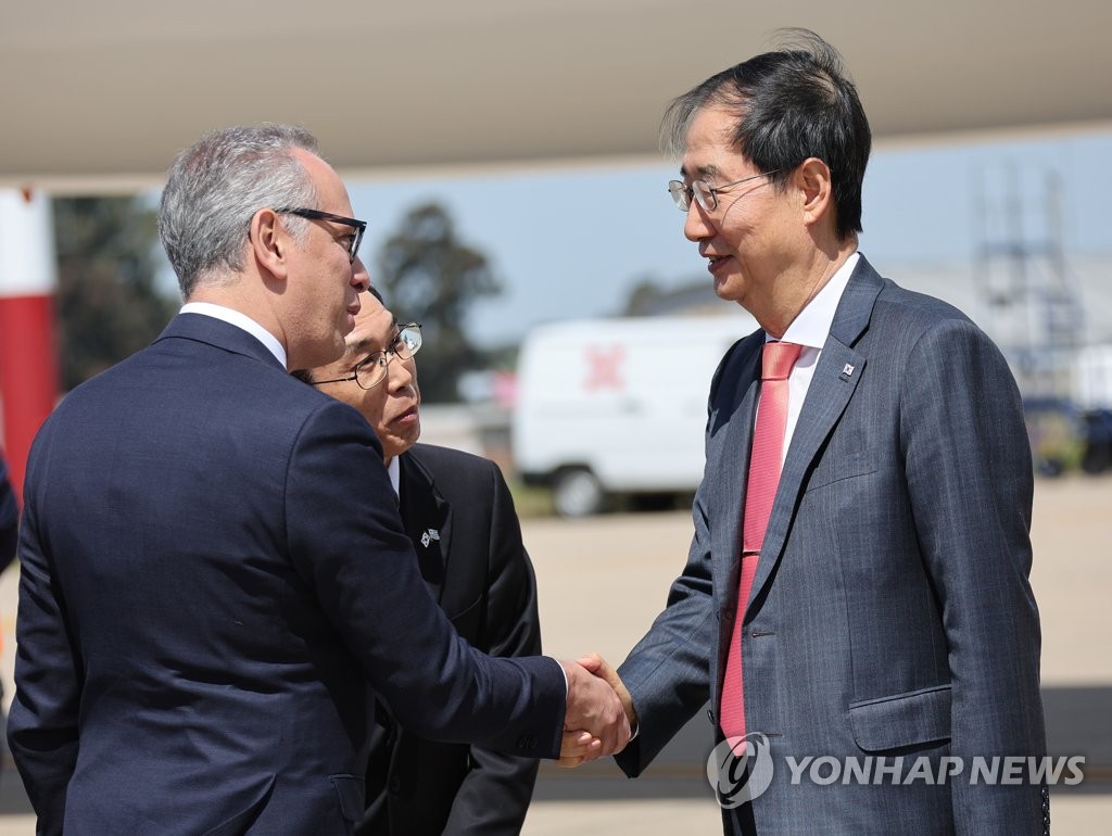 Prime Minister Han Duck-soo (R) is greeted by a Uruguayan official after arriving in Montevideo for an official visit on Oct. 12, 2022. (Yonhap) 