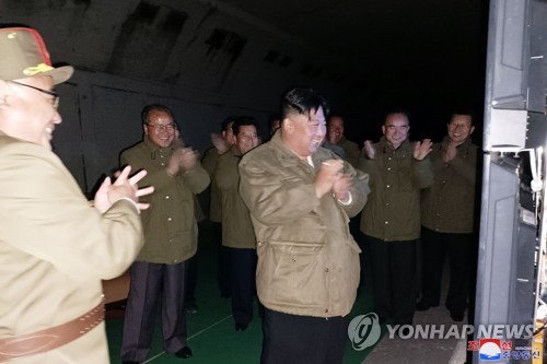 This photo, released by the Korean Central News Agency on Oct. 13, 2022, shows North Korean leader Kim Jong-un (C) clapping while watching the test-firing of two long-range strategic cruise missiles on the scene the previous day. The missiles flew for &quot;10,234 seconds along an oval and pattern-8 flight orbits in the sky above the West Sea of Korea and clearly hit the target 2,000 km away,&quot; according to the North Korean state media. (For Use Only in the Republic of Korea. No Redistribution) (Yonhap)