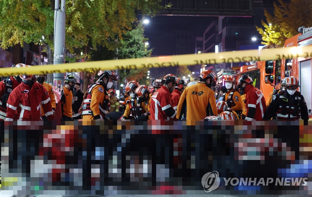 Rescuers move injured people in Seoul's Itaewon district on Oct. 30, 2022. (Yonhap)