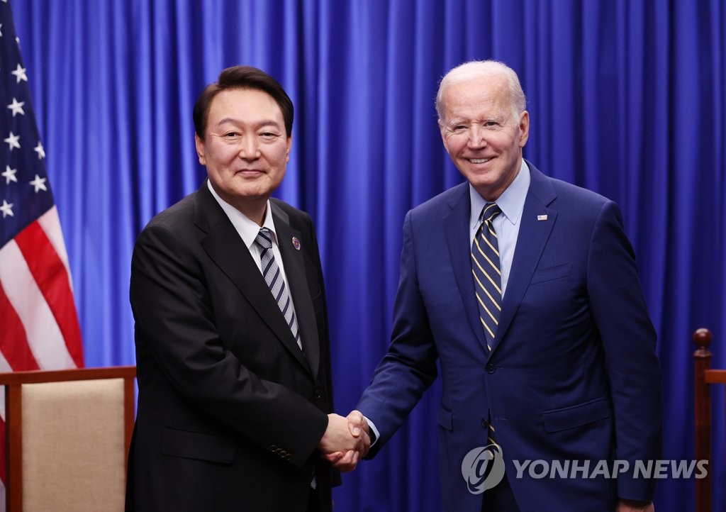 Le président Yoon Suk-yeol (à g.) et le président américain Joe Biden échangent une poignée de main lors de leur sommet bilatéral le dimanche 13 novembre 2022 dans un hôtel de Phnom Penh. 