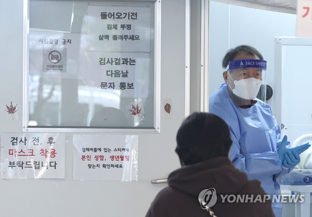 A medical worker guides people at a COVID-19 testing station in a community health center in Nowon, northern Seoul, on Nov. 21, 2022. (Yonhap) 