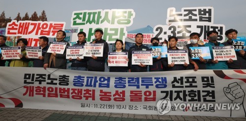 Des membres de la Confédération coréenne des syndicats (KCTU) portent des pancartes déclarant une grève générale lors d'une conférence de presse devant l'Assemblée nationale, le mardi 22 novembre 2022.
