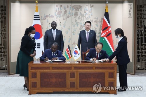 This photo, provided by the presidential office, shows South Korean President Yoon Suk-yeol (R, back row) and Kenyan President William Ruto (L, back row) watching their ministers sign an agreement to raise the ceiling of Seoul's development cooperation loans to the East African country, at the presidential office in Yongsan, Seoul, on Nov. 23, 2022. (PHOTO NOT FOR SALE) (Yonhap)