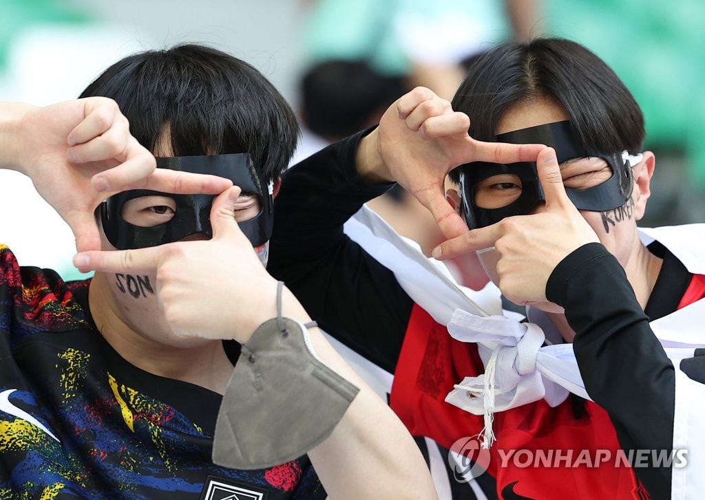 Fans of the South Korean national football team pose in custom-made mask in show of support for captain Son Heung-min before South Korea's Group H match against Uruguay at the FIFA World Cup at Education City Stadium in Al Rayyan, west of Doha, on Nov. 24, 2022. (Yonhap)