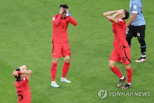 South Korean players Hwang Ui-jo, Son Heung-min and Lee Jae-sung (L-R) react to Hwang's missed scoring opportunity against Uruguay during the countries' Group H match at the FIFA World Cup at Education City Stadium in Al Rayyan, west of Doha, on Nov. 24, 2022. (Yonhap)
