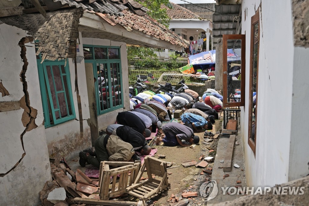 지진으로 파손된 사원 밖에서 금요 예배를 하는 인니 무슬림들