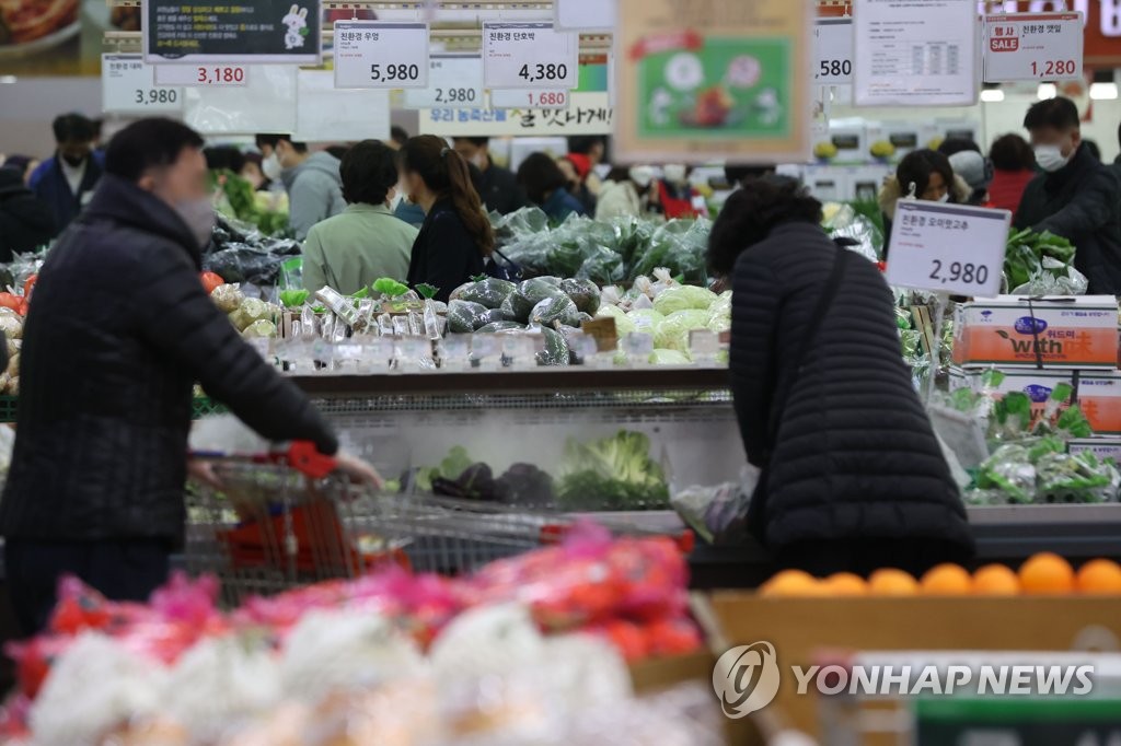 Shoppers choose vegetables at a supermarket in Seoul on Nov. 27, 2022. (Yonhap)