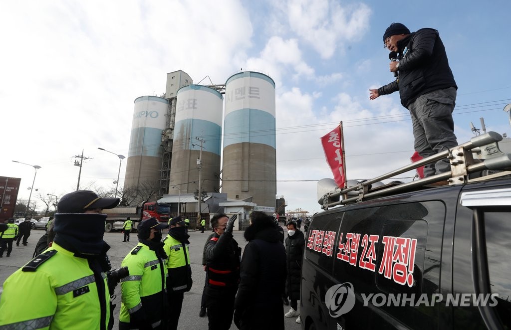 Police confront a striking union member of the Cargo Truckers Solidarity Union at the operation site of Sampyo Cement Co. in Incheon, 27 kilometers west of Seoul, on Dec. 1, 2022. (Yonhap) 