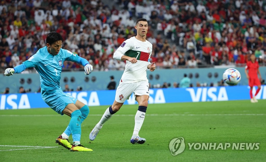 South Korean goalkeeper Kim Seung-gyu clears the ball ahead of Cristiano Ronaldo of Portugal during the countries' Group H match at Education City Stadium in Al Rayyan, west of Doha, on Dec. 2, 2022. (Yonhap)