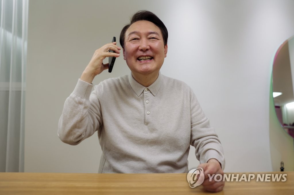 President Yoon Suk-yeol talks on the phone with members of South Korea's national football team from his residence in Seoul on Dec. 3, 2022, in this photo provided by the presidential office. (PHOTO NOT FOR SALE) (Yonhap)