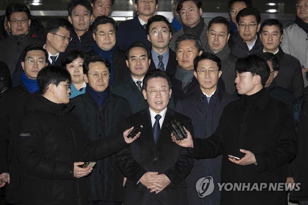 The main opposition Democratic Party leader Lee Jae-myung (C) takes reporters' questions in front of the Seongnam branch of the Suwon District Prosecutors Office in Seongnam, just south of Seoul, in this file photo taken Jan. 10, 2023, after being questioned by prosecutors over bribery allegations. (Pool photo) (Yonhap)