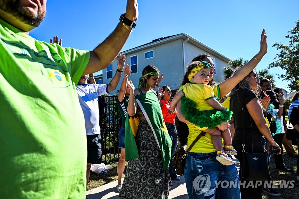Apoiadores oram por uma rápida recuperação em frente à residência do ex-presidente brasileiro Bolsonaro nos EUA.