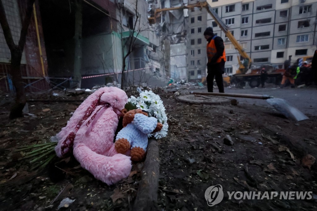 러시아군 폭격으로 붕괴한 우크라 아파트 앞에 놓인 인형들