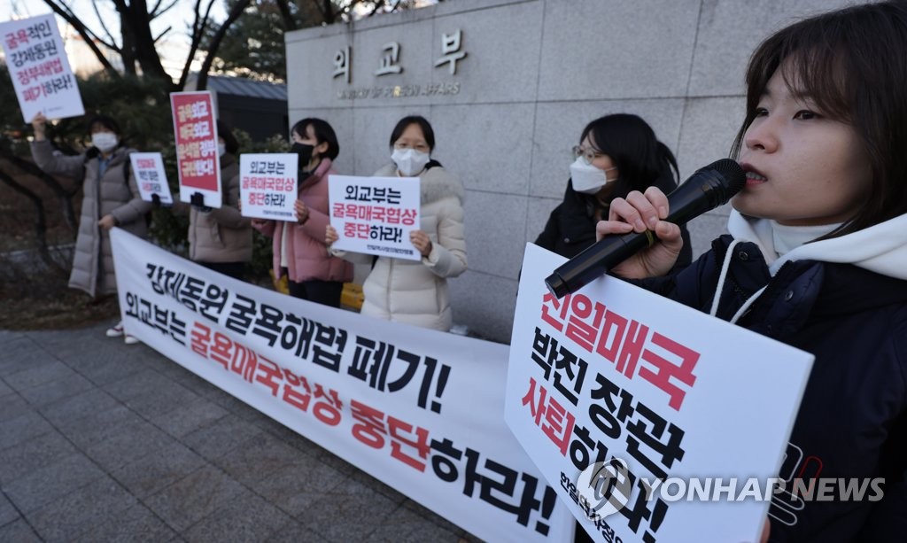 韓日の外交当局が協議を行っているソウルの外交部庁舎前で交渉の中止を求める集会を開く市民団体の関係者ら＝３０日、ソウル（聯合ニュース）