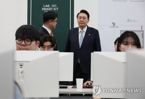 El presidente surcoreano, Yoon Suk Yeol (dcha., fondo), visita, el 1 de febrero de 2023, una clase de formación profesional del Instituto Nacional de Tecnología de Kumoh, en Gumi, a 202 kilómetros al sureste de Seúl. 