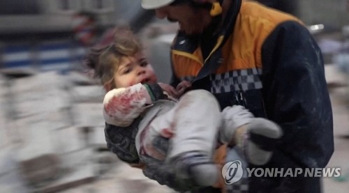 튀르키예발 강진으로 무너진 시리아 건물서 다친 아기 옮기는 구조대원