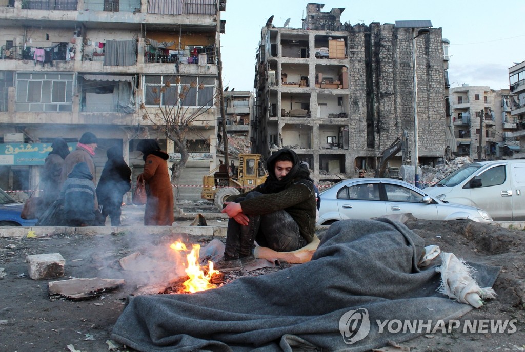 집에서 대피한 뒤 거리에서 모닥불 쬐는 시리아 남성