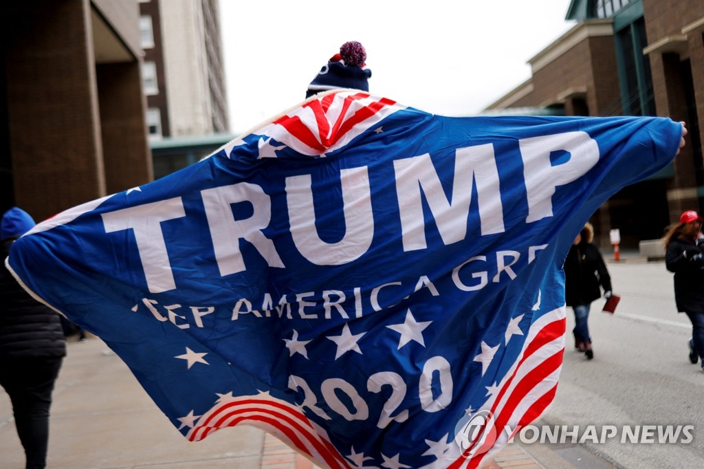 트럼프 지지 깃발을 등에 감싸는 美 아이오와 주민
