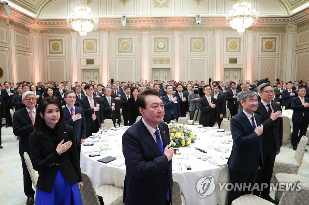 在外公館長との夕食会で国旗に敬礼する尹大統領（中央）ら＝２７日、ソウル（聯合ニュース）