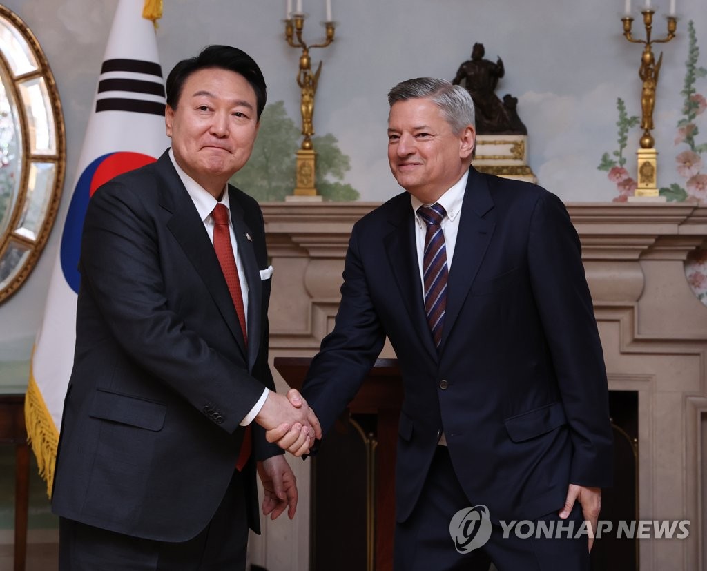 President Yoon Suk Yeol (L) shakes hands with Netflix co-CEO Ted Sarandos after the company announced plans to invest US$2.5 billion in South Korea over the next four years, at Blair House in Washington on April 24, 2023. (Yonhap)
