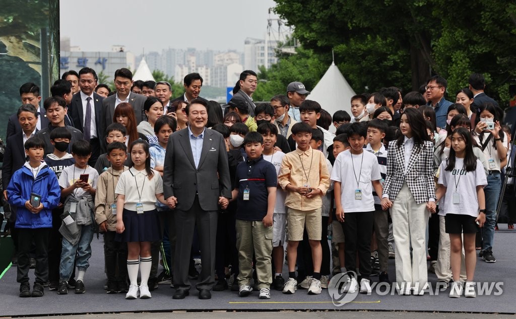 President Yoon Suk Yeol (5th from L, front row) and his wife, Kim Keon Hee (2nd from R, front row), along with a group of children, enter a ceremony at Yongsan Children's Garden in front of the presidential office in Seoul on May 4, 2023, to open the newly constructed park on the eve of the Children's Day holiday. Yongsan Children's Garden occupies around 300,000 square meters of land previously used as a base by U.S. forces stationed in South Korea. (Yonhap)