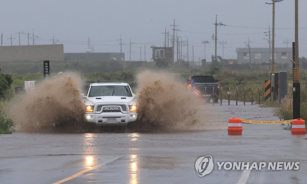 Esta foto de archivo muestra un automóvil moviéndose a lo largo de una carretera inundada en la ciudad de Seogwipo en la isla de Jeju, la más grande de Corea del Sur, el 4 de mayo de 2023. (Yonhap)