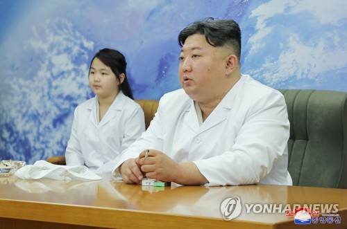 North Korean leader Kim Jong-un (R), along with his daughter Ju-ae, is pictured as he meets with members of the Non-permanent Satellite Launch Preparatory Committee in Pyongyang on May 16, 2023, to inspect the country's first military reconnaissance satellite, in this file photo released by the North's official Korean Central News Agency. Kim gave the green light for its "future action plan," Pyongyang's state media said. (For Use Only in the Republic of Korea. No Redistribution) (Yonhap)
