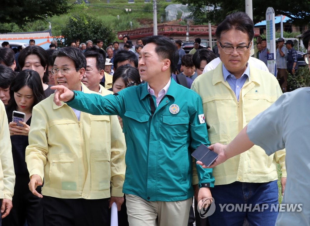 El líder del gobernante Partido del Poder Popular (PPP), Kim Gi-hyeon, camina en una región afectada por el desastre en la ciudad sureña de Gongju, a 125 kilómetros al sur de Seúl, con funcionarios del partido el 17 de julio de 2023. (Yonhap)