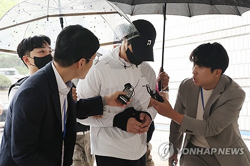 A 30-year-old suspect, identified by his surname Hong and accused of threatening another driver with a weapon over a parking space dispute, enters a Seoul court to attend an arrest warrant hearing on Sept. 13, 2023. (Yonhap)