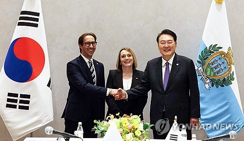 Le président Yoon Suk Yeol (à dr.) échange une poignée de main avec les capitaines-régents de Saint-Marin, Adele Tonnini (au c.) et Alessandro Scarano, lors d'une réunion à New York, le lundi 18 septembre 2023.