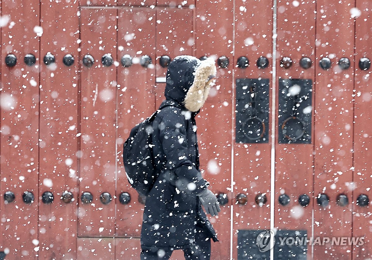 Una persona camina por una calle cerca del Palacio Deoksu, en el centro de Seúl, el 30 de diciembre de 2023. La agencia meteorológica estatal emitió un aviso de fuertes nevadas para partes de la capital y áreas circundantes más temprano ese día.  (Yonhap)