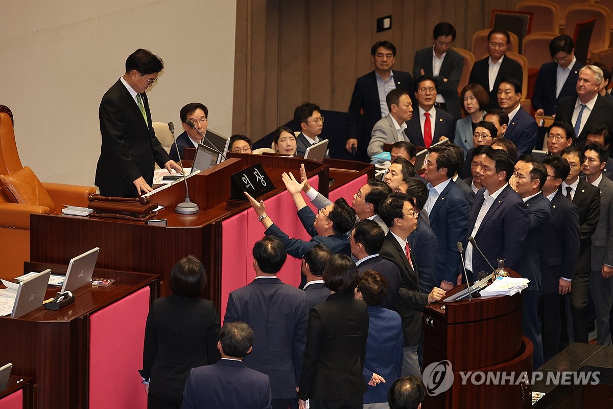 Los legisladores del Partido del Poder Popular (PPP) protestan contra el presidente de la Asamblea Nacional, Woo Won-shik (izq.), después de que Woo les pidiera que pusieran fin a su obstruccionismo en una sesión plenaria el 4 de julio de 2024. (Yonhap)