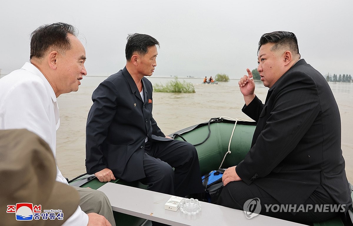 Esta fotografía, publicada por la Agencia Central de Noticias de Corea del Norte, el 31 de julio de 2024, muestra al líder norcoreano Kim Jong-un (derecha) recorriendo una zona afectada por las inundaciones antes de presidir una reunión ampliada de emergencia del politburó del gobernante Partido de los Trabajadores de Corea. (Para uso exclusivo en la República de Corea. No se permite su distribución) (Yonhap)