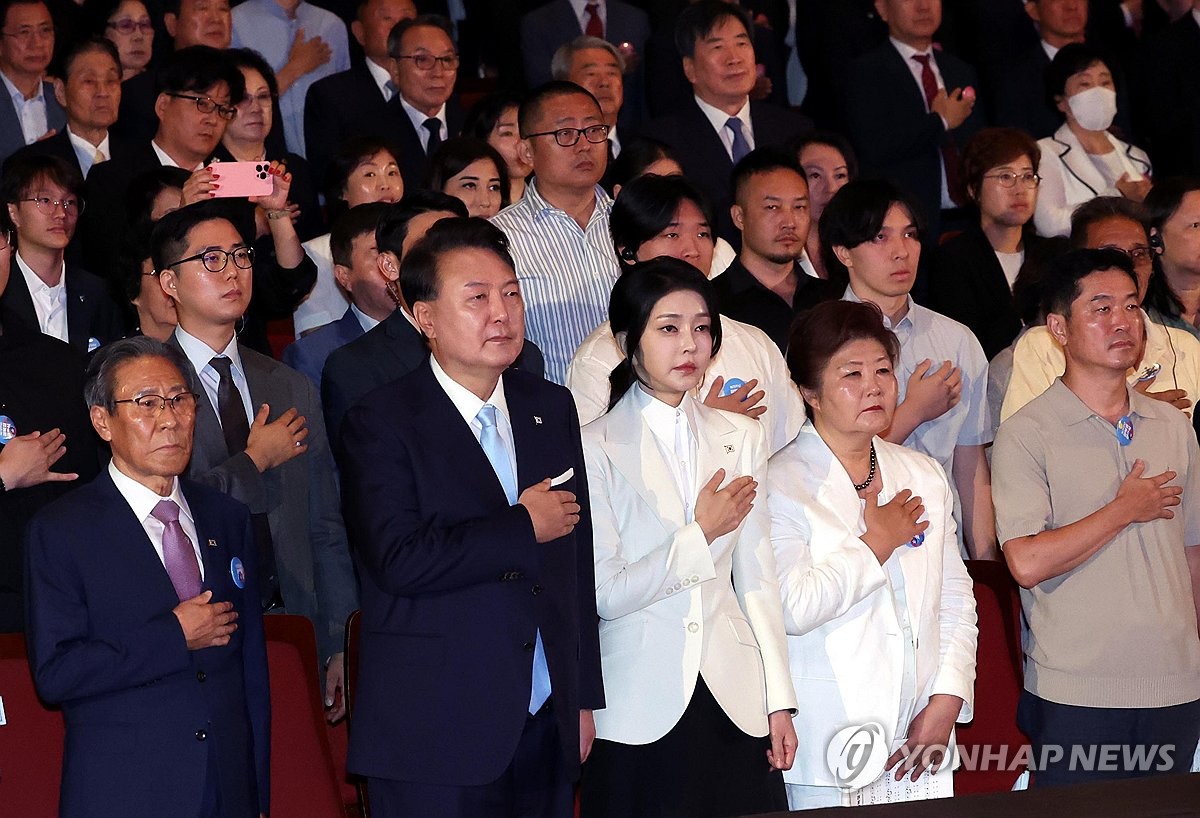 El presidente Yoon Suk Yeol (segundo desde la izq.) y la primera dama Kim Keon Hee (tercera desde la izq.) saludan a la bandera nacional durante una ceremonia en conmemoración del 79.º Día de la Liberación celebrada en el Centro Sejong para las Artes Escénicas en Seúl el 15 de agosto de 2024. (Foto de grupo) (Yonhap)