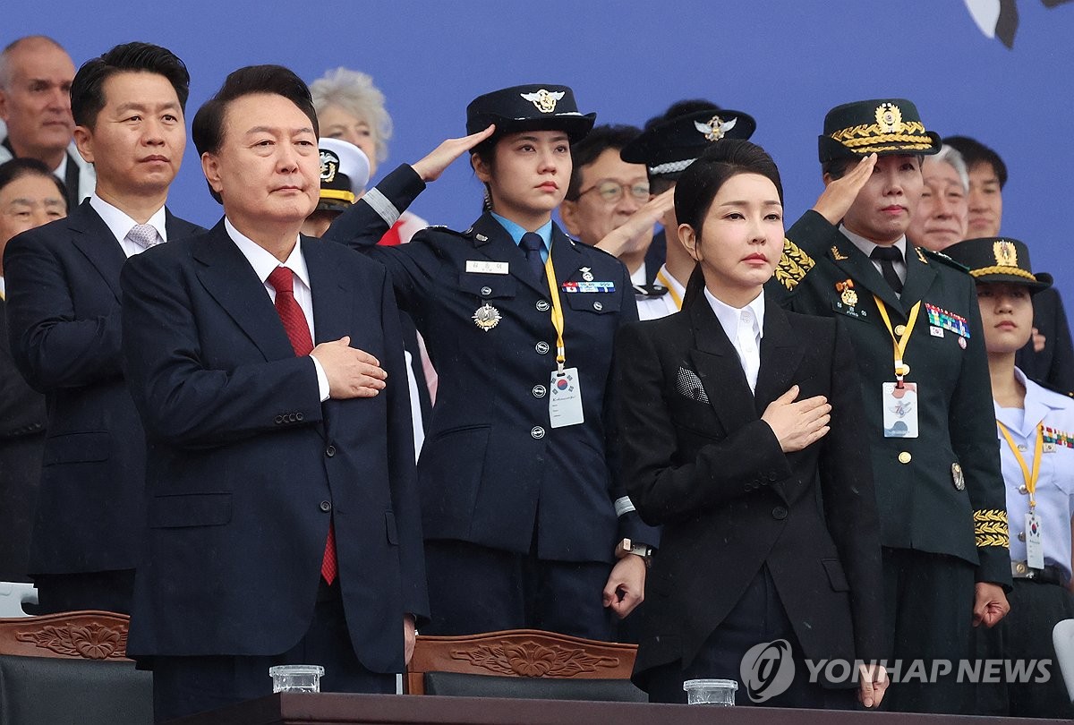 El presidente Yoon Sul Yeol (izq., primera fila) y la primera dama Kim Keon Hee (segunda desde la izq., primera fila) saludan la bandera nacional durante una ceremonia que conmemora el 76º Día de las Fuerzas Armadas, celebrada en la Base Aérea de Seúl, al sur de Seúl, el 2 de octubre de 2019. 1 de enero de 2024. (Foto de la piscina) (Yonhap)