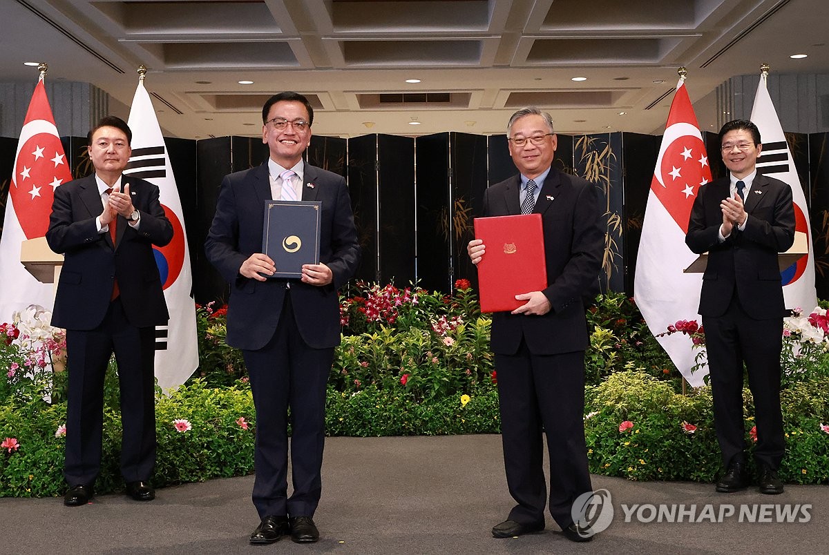 Choi Sang-mok (segundo por la izquierda), viceprimer ministro y ministro de Finanzas de Corea del Sur, y su homólogo de Singapur, Gan Kim Yong (segundo por la derecha), posan para una fotografía tras firmar un memorando de entendimiento sobre cooperación en materia de gas natural licuado, en la presencia del presidente surcoreano, Yoon Suk Yeol (i), y el primer ministro de Singapur, Lawrence Wong, en el Parlamento de Singapur el 8 de octubre de 2024. (Yonhap)